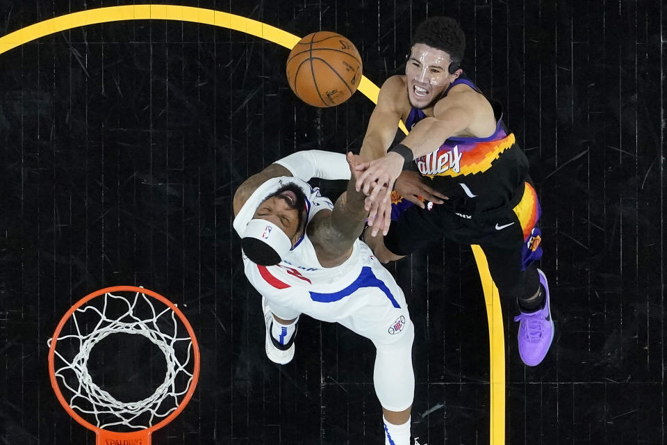 Phoenix Suns guard Devin Booker (1) shoots over Los Angeles Clippers forward Marcus Morris Sr. during the second half of game 5 of the NBA basketball Western Conference Finals, Monday, June 28, 2021, in Phoenix. (AP Photo/Matt York)
