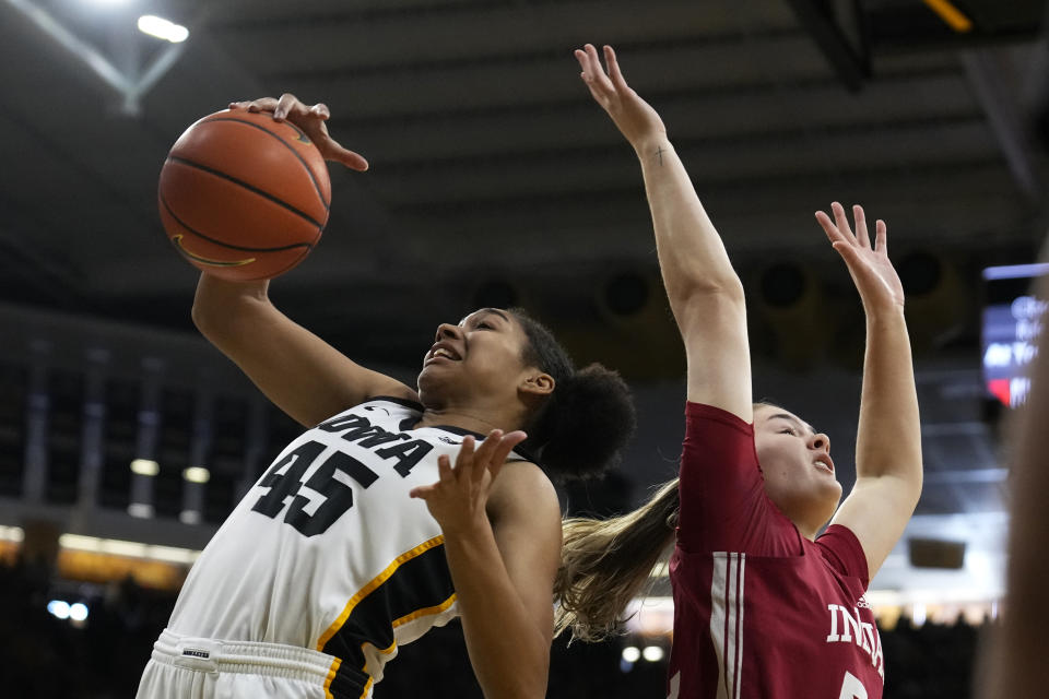 Iowa forward Hannah Stuelke (45) fights for a rebound with Indiana forward Lilly Meister, right, during the first half of an NCAA college basketball game, Sunday, Feb. 26, 2023, in Iowa City, Iowa. (AP Photo/Charlie Neibergall)