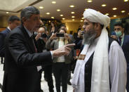Russian presidential envoy to Afghanistan Zamir Kabulov, left, speaks to a member of political delegation from the Afghan Taliban's movement Mawlawi Shahabuddin Dilawar, right, before the opening of talks involving Afghan representatives in Moscow, Russia, Wednesday, Oct. 20, 2021. Russia invited the Taliban and other Afghan parties for talks voicing hope they will help encourage discussions and tackle Afghanistan's challenges. (AP Photo/Alexander Zemlianichenko, Pool)