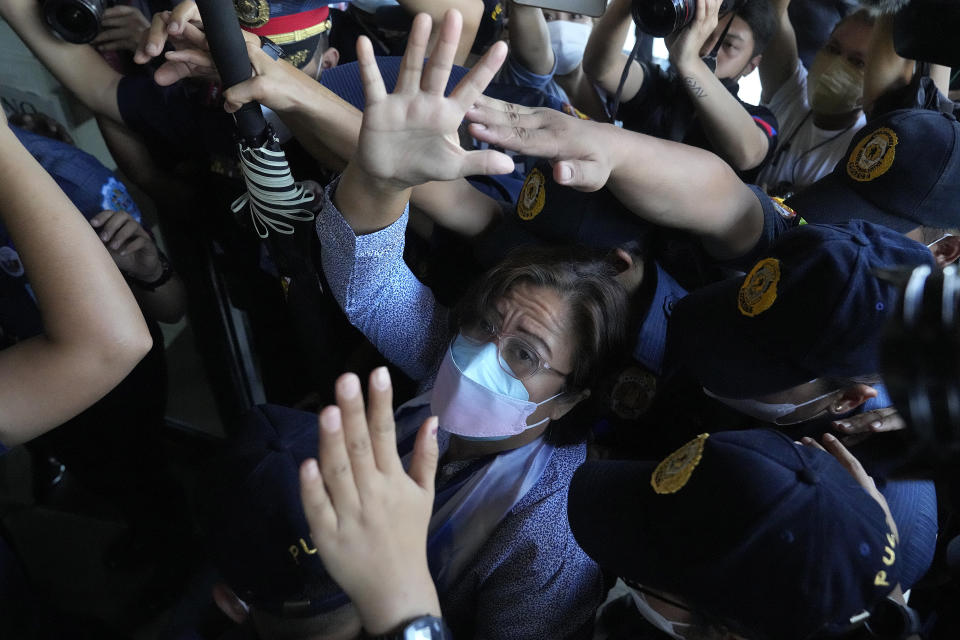 Detained former opposition Sen. Leila de Lima waves under tight security as she arrives to attend a court hearing which later postponed in Muntinlupa, Philippines, Monday, Oct. 10, 2022. Human rights activists pressed their call Monday for the immediate release of de Lima after she was taken hostage in a rampage by three Muslim militants in a failed attempt to escape from a maximum-security jail. (AP Photo/Aaron Favila)