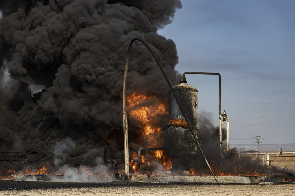 A smoke rises from an oil depot struck by Turkish air force near the town of Qamishli, Syria, Wednesday, Nov. 23, 2022. Turkey's president says he will carry out a land invasion into Kurdish areas of northern Syria. Recep Tayyip Erdogan's statement in Ankara Wednesday came after Turkey carried out a barrage of airstrikes on suspected Kurdish militants in northern Syria and Iraq in recent days. (AP Photo/Baderkhan Ahmad)