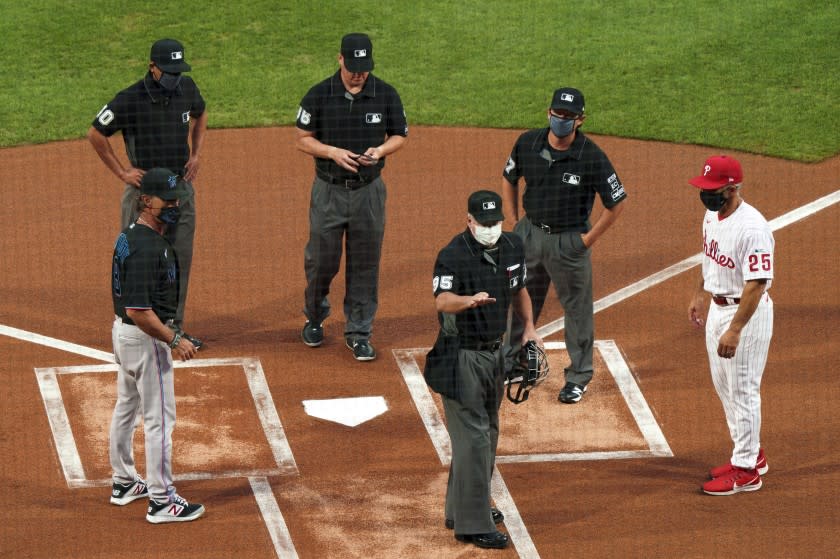 Umpires speak with managers before a game.