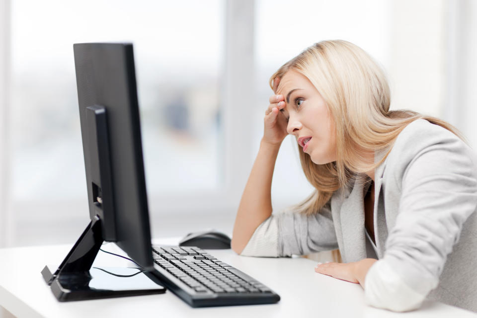 Woman looking at computer screen with a disappointed expression