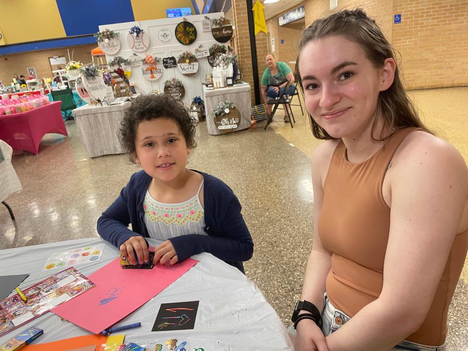 Graduated Cadet Lexi White returns to her alma mater to help Lillie Corrier, 8, with crafts at the fourth annual Community Bazaar at Karns High School Saturday, April 30, 2022.