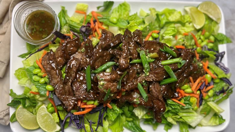 salad with mongolian beef on white platter