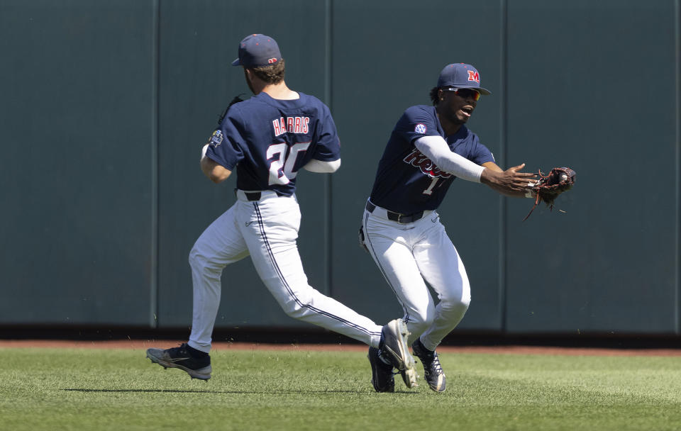 Mississippi's TJ McCants, right, catches a fly ball to center field by Oklahoma's Tanner Tredaway in the seventh inning in Game 2 of the NCAA College World Series baseball finals, Sunday, June 26, 2022, in Omaha, Neb. (AP Photo/Rebecca S. Gratz)