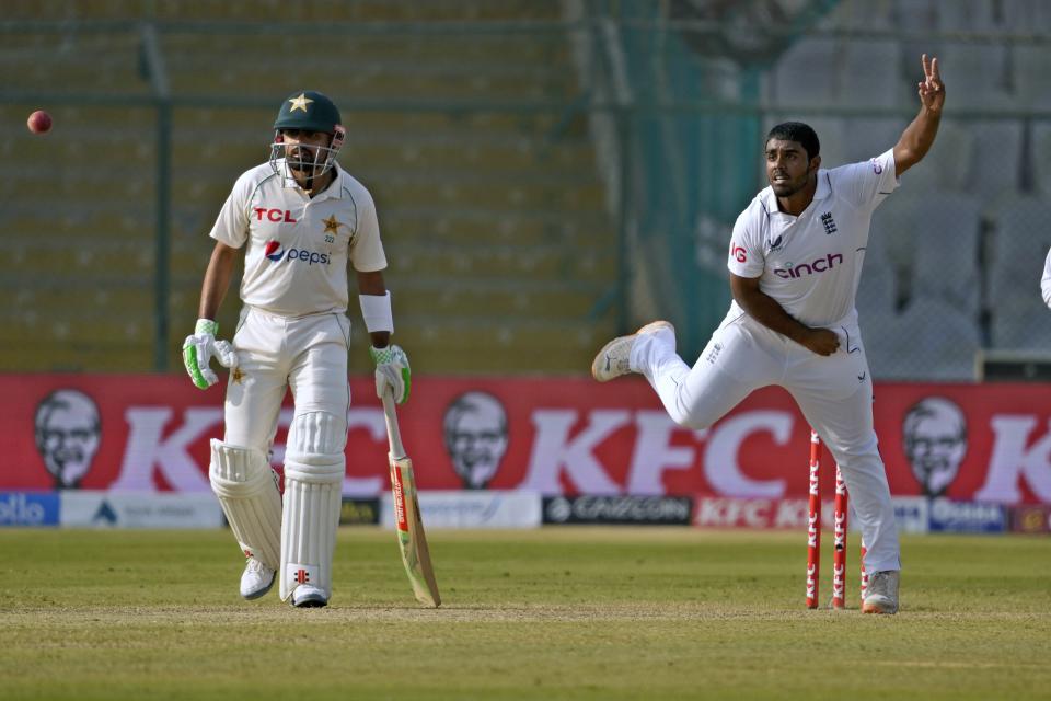 England's Rehan Ahmed, right, bowls as Pakistan's Babar Azam watches during the first day of third test cricket match between England and Pakistan, in Karachi, Pakistan, Saturday, Dec. 17, 2022. (AP Photo/Fareed Khan)