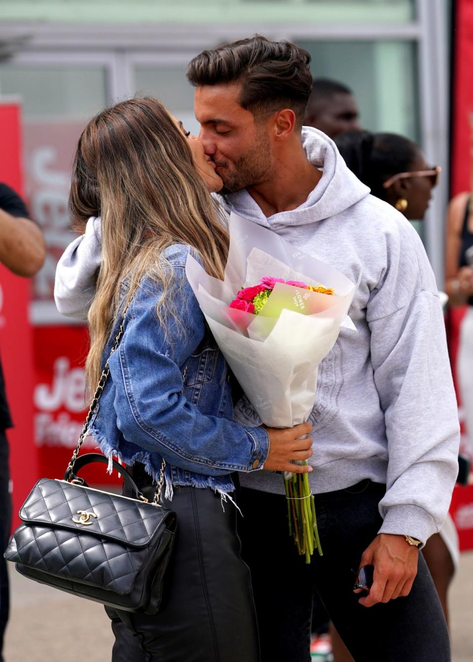 Ekin-Su Culculoglu and Davide Sanclimenti smooched for the cameras outside the airport in Essex (PA)