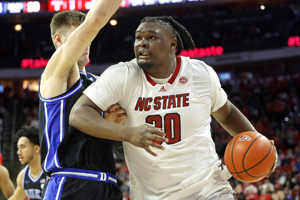 North Carolina State's DJ Burns Jr., right, drives the ball into Duke's Kyle Filipowski, front left, during the second half of an NCAA college basketball game in Raleigh, N.C., Monday, March 4, 2024. (AP Photo/Karl B DeBlaker)