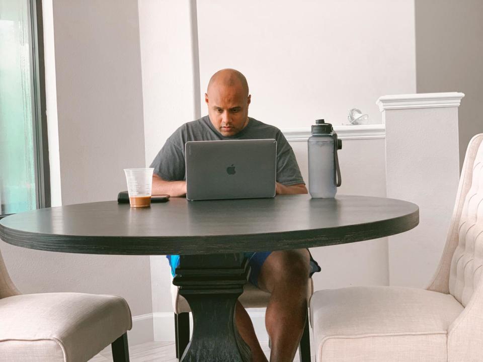 A man working at a laptop at a table.