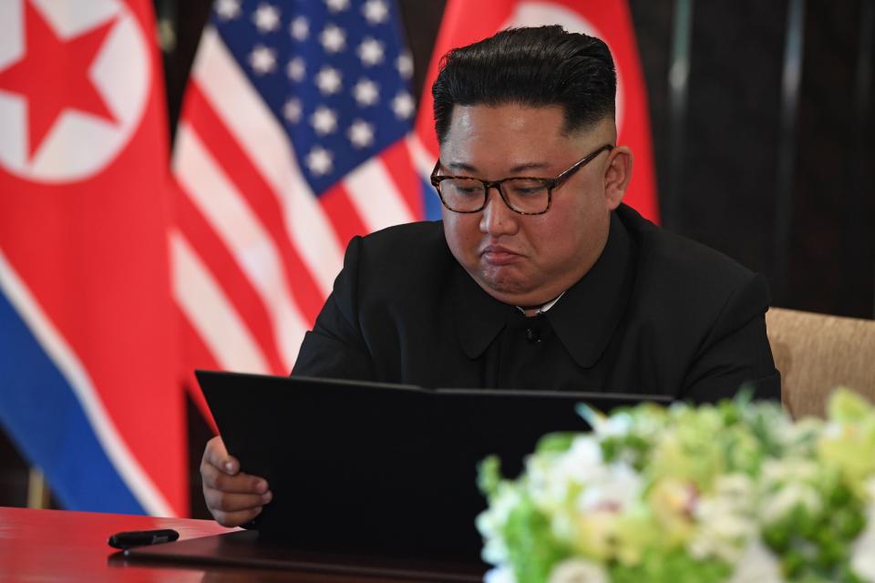 Kim looks at his document at a signing ceremony with Trump. The brief, vague joint statement included a clause stating "the DPRK commits to work toward complete denuclearization of the Korean Peninsula." (Photo: Saul Loeb/AFP/Getty Images)