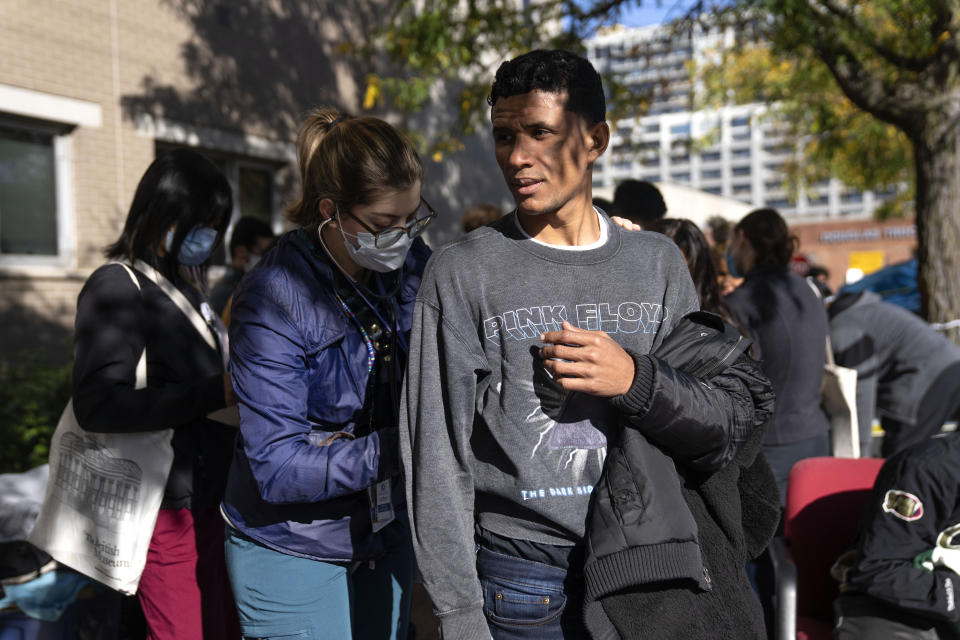 UIC med student Sara Cooper, left, examines Abrahan Belizario, 28, of Peru, outside of the 1st District police station where migrants are camped, Saturday, Oct. 7, 2023, in Chicago. (AP Photo/Erin Hooley)