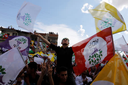 People wave flags as they attend a campaign event by Turkey's main pro-Kurdish Peoples' Democratic Party (HDP) in Silvan, a town in Diyarbakir province, Turkey, June 5, 2018. Picture taken June 5, 2018. REUTERS/Umit Bektas