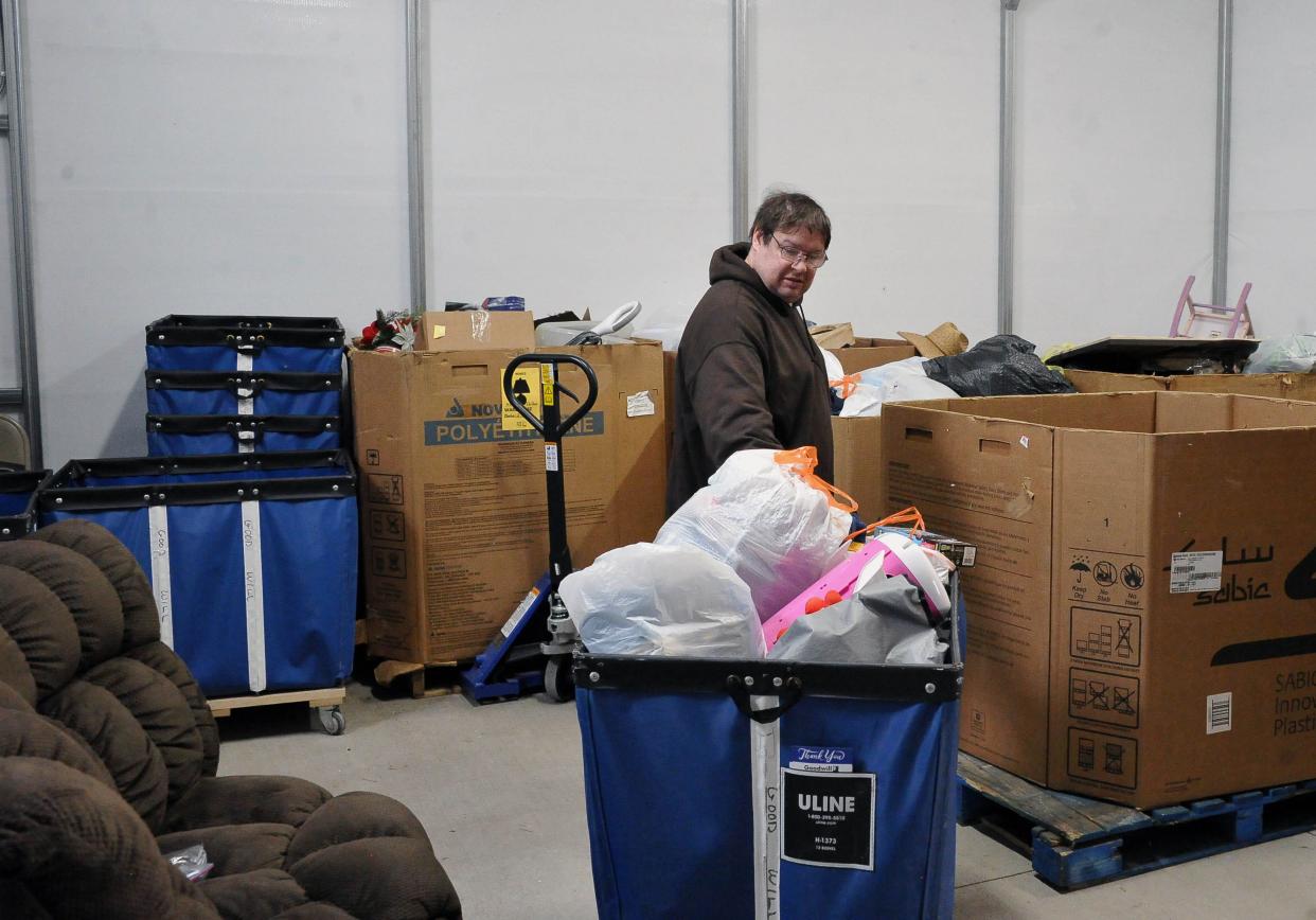 Don King moves a cart of new donations to be sorted at the new Goodwill donation center at 27 south Cochran Street in Dalton