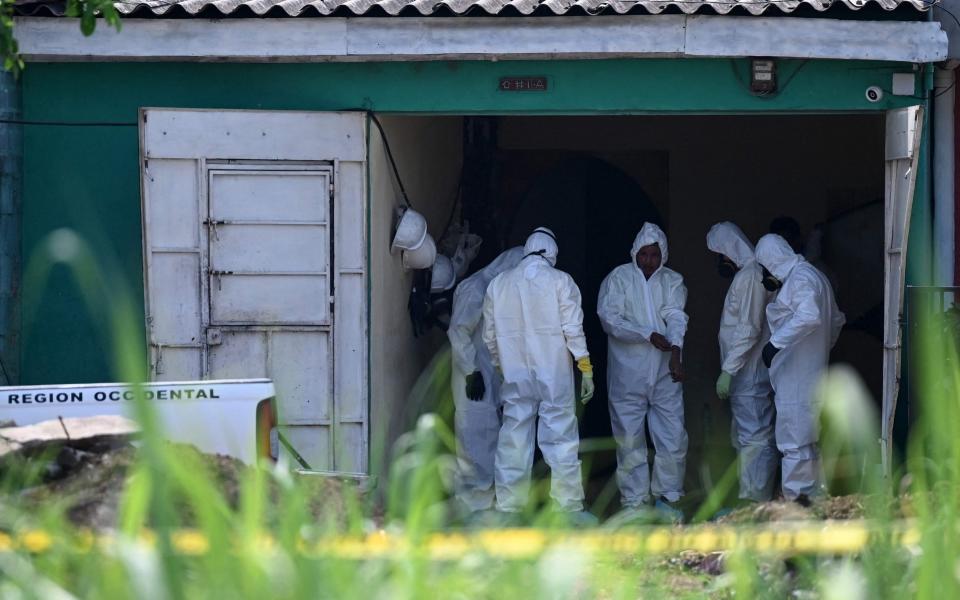 Forensic scientists, members of the Attorney General of the Republic and police officers work at the home of former police officer Hugo Ernesto Osorio, captured by members of the National Civil Police, as the main suspect of killing approximately 16 people in Chalchuapa, El Salvador, on May 20, 2021 - MARVIN RECINOS /AFP