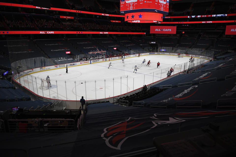 The Washington Capitals and the Buffalo Sabres compete amongst empty stands during the first period of an NHL hockey game, Friday, Jan. 22, 2021, in Washington. (AP Photo/Nick Wass)