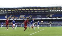 Players play in front of empty stands during the English Premier League soccer match between Everton and Liverpool at Goodison Park in Liverpool, England, Sunday, June 21, 2020. (Peter Powell/Pool via AP)