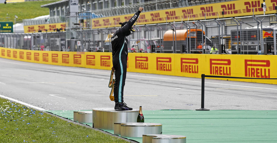 Mercedes driver Lewis Hamilton of Britain reacts alone on the podium after winning the Styrian Formula One Grand Prix race at the Red Bull Ring racetrack in Spielberg, Austria, Sunday, July 12, 2020. (Leonhard Foeger/Pool via AP)