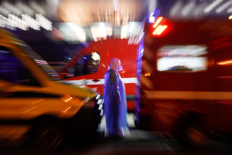 A health worker is pictured between ambulances with COVID-19 patients as they wait in the queue at Santa Maria hospital, amid the coronavirus disease (COVID-19) pandemic in Lisbon