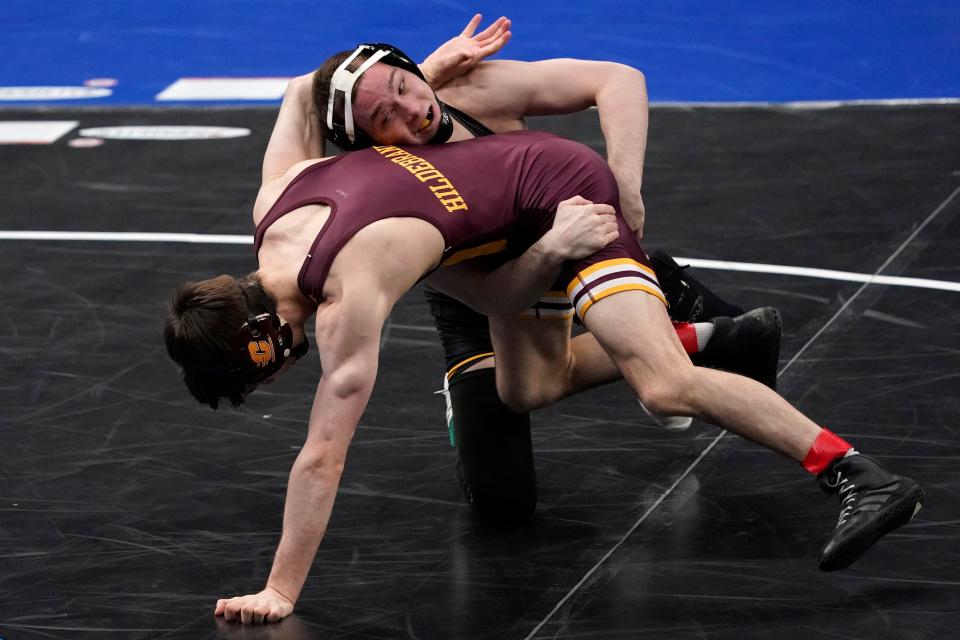 Iowa's Spencer Lee, top, takes on Central Michigan's Drew Hildebrandt during their 125-pound match in the semifinal round of the NCAA wrestling championships Friday, March 19, 2021, in St. Louis. (AP Photo/Jeff Roberson)