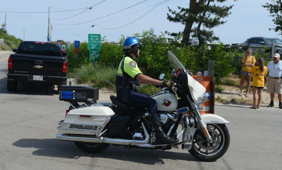 Dennis Police monitor traffic at the entrance to Mayflower Beach in Dennis where the parking lot was full early on a recent Saturday morning.