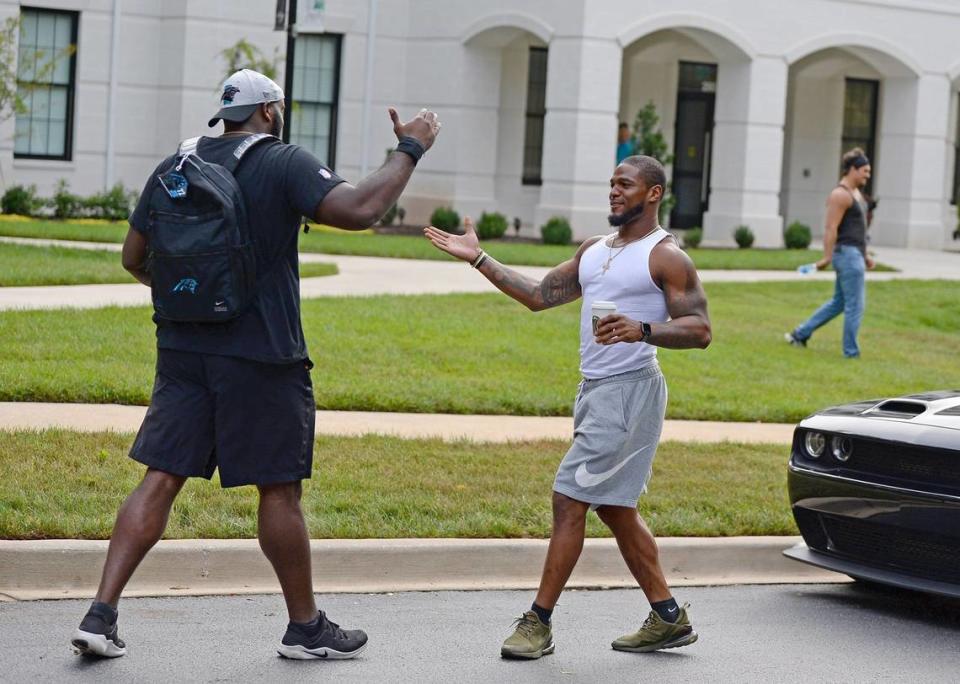 Carolina Panthers tackle Taylor Moton, left and linebacker Denzel Perryman, right, greet one another after arriving at their dormitory on the campus of Wofford College in Spartanburg, SC on Tuesday, July 27, 2021. The Panthers will hold their first training camp practice on Wednesday, July 28, 2021.