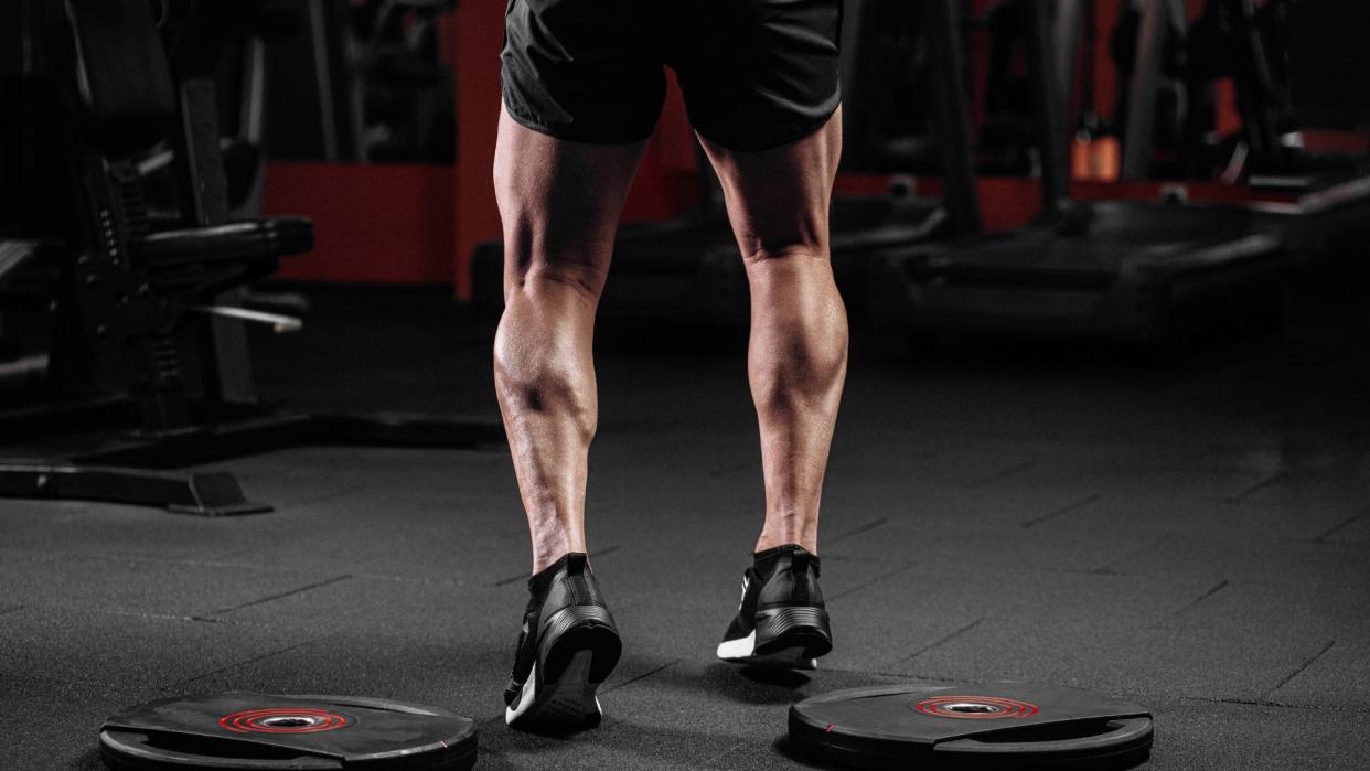  Man standing in the gym with muscular calves. 