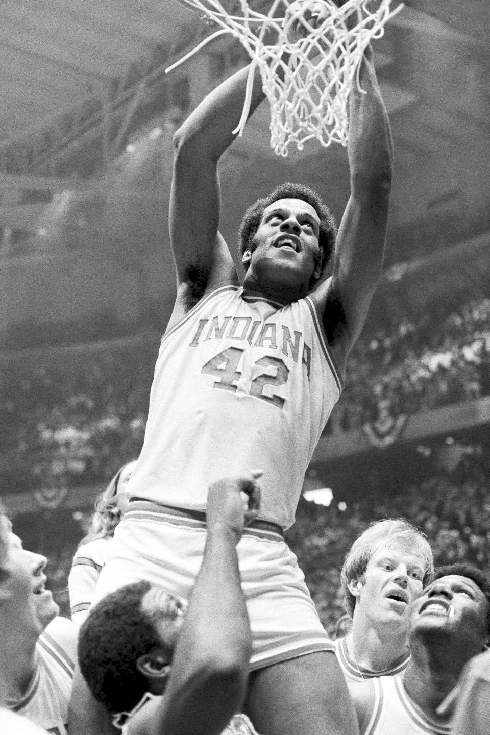 FILE - Indiana's Scott May (42) cuts the net from the basket after Indiana won the NCAA college basketball championship over Michigan in Philadelphia, Monday, March 29, 1976. At lower right is Kent Benson of Indiana, named Most Valuable Player of the tournament. Bob Knight won three national championships at Indiana, but his first was perfect. Led by high-scoring forward Scott May, the 1975-76 Hoosiers went 32-0, capped by a blowout win over Michigan in the national title game.(AP Photo/File)