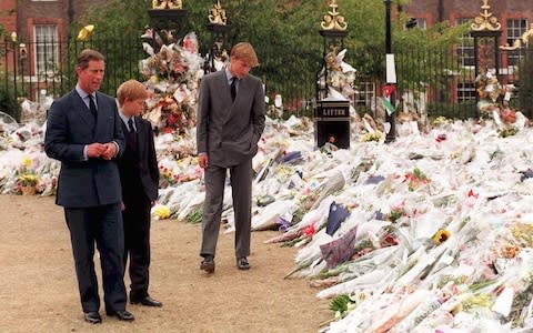 The Prince of Wales and Princes William and Harry inspect thousands of bouquets of floral tributes to their mother Diana, Princess of Wales, outside Kensington Palace on September 5, 1997. - Credit: AFP