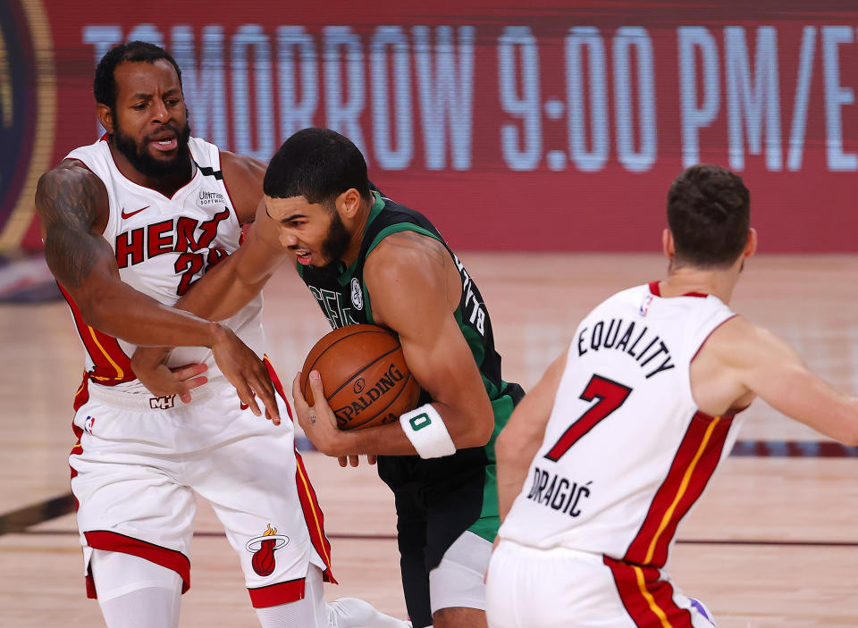 LAKE BUENA VISTA, FLORIDA - SEPTEMBER 25: Jayson Tatum #0 of the Boston Celtics drives the ball against Andre Iguodala #28 of the Miami Heat during the second quarter in Game Five of the Eastern Conference Finals during the 2020 NBA Playoffs at AdventHealth Arena at the ESPN Wide World Of Sports Complex on September 25, 2020 in Lake Buena Vista, Florida. NOTE TO USER: User expressly acknowledges and agrees that, by downloading and or using this photograph, User is consenting to the terms and conditions of the Getty Images License Agreement.  (Photo by Mike Ehrmann/Getty Images)