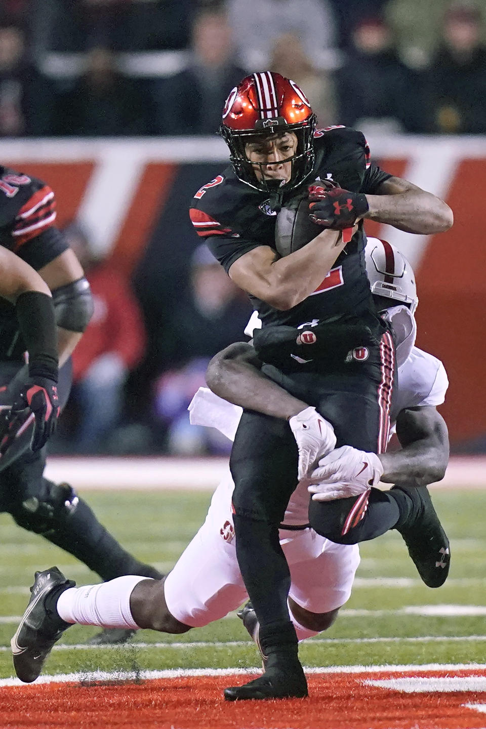 Utah running back Micah Bernard (2) carries the ball as Stanford defensive end David Bailey, rear, makes a tackle during the first half of an NCAA college football game Saturday, Nov. 12, 2022, in Salt Lake City. (AP Photo/Rick Bowmer)