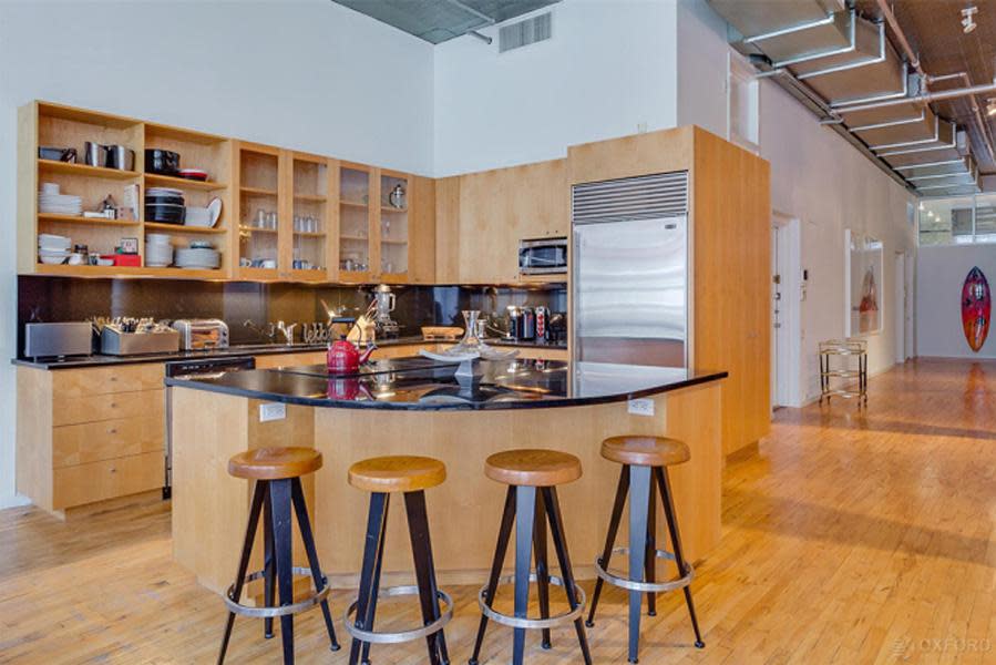 <br>The open-plan kitchen features stainless steel appliances and black granite countertops.