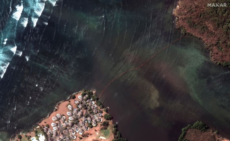 A satellite image shows an oil containment boom across Petit Trou Lagoon