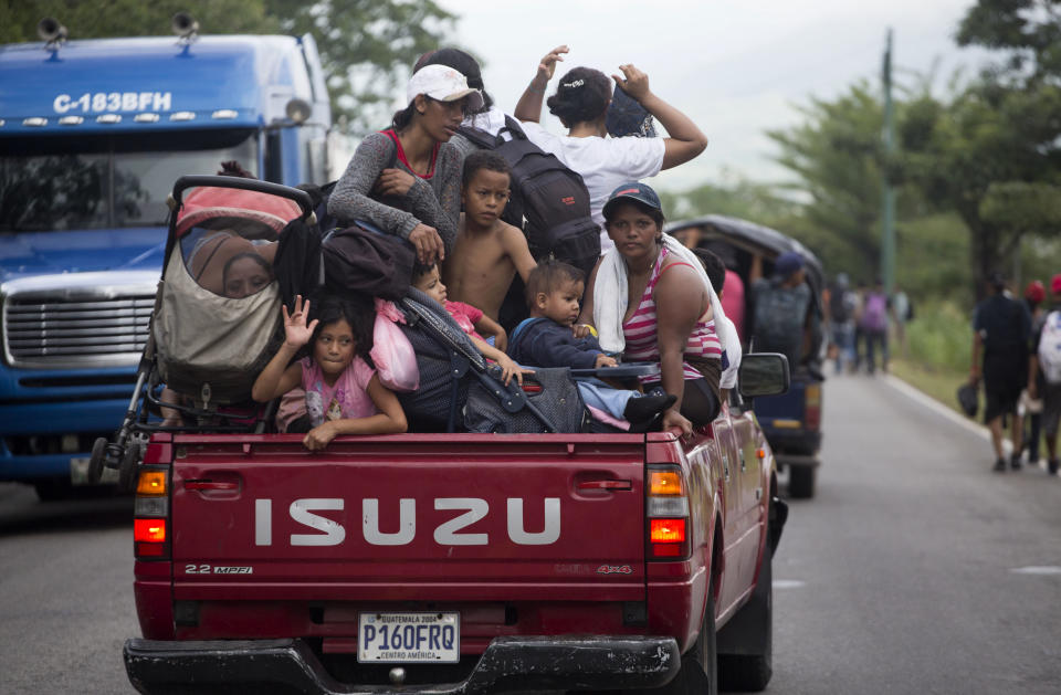 Migrantes hondureños que marchan hacia Estados Unidos en caravana viajan gratis en la parte trasera de la camioneta de un conductor mientras avanzan por Zacapa, Guatemala, el miércoles 17 de octubre de 2018. (AP Foto / Moises Castillo)