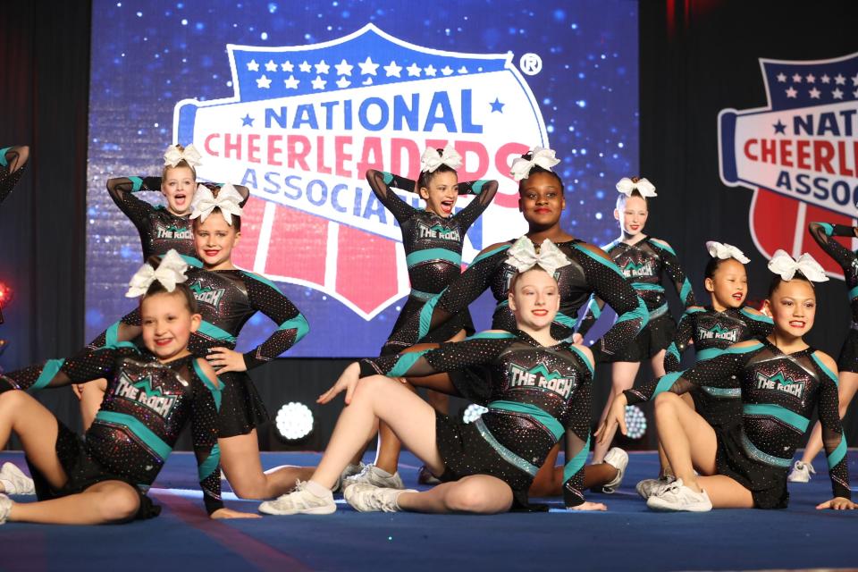 Members of the White All-Star cheer team from Modern American Cheer in Corpus Christi pose after completing a routine at NCA All-Star Nationals, a competition held Feb. 24-26, 2023, at the Kay Bailey Hutchison Convention Center in Dallas.