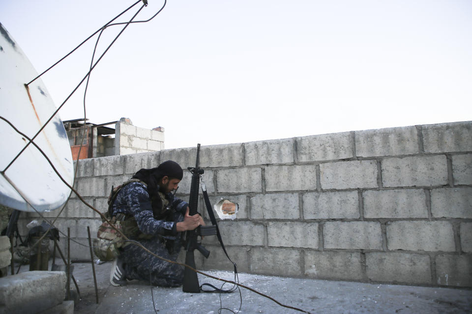 A soldier with the U.S.-backed Syrian Democratic Forces h checks area in Hassakeh, Syria, Tuesday, Jen. 25, 2022. After breaking into the prison late Thursday, IS militants were joined by others rioting inside the facility that houses over 3,000 inmates, including hundreds of minors. They took hostages from among the prison staff and have since been holed up in the northern wing at one end of the facility, known as al-Sinaa or Gweiran prison. (AP Photo/Hogir Al Abdo)