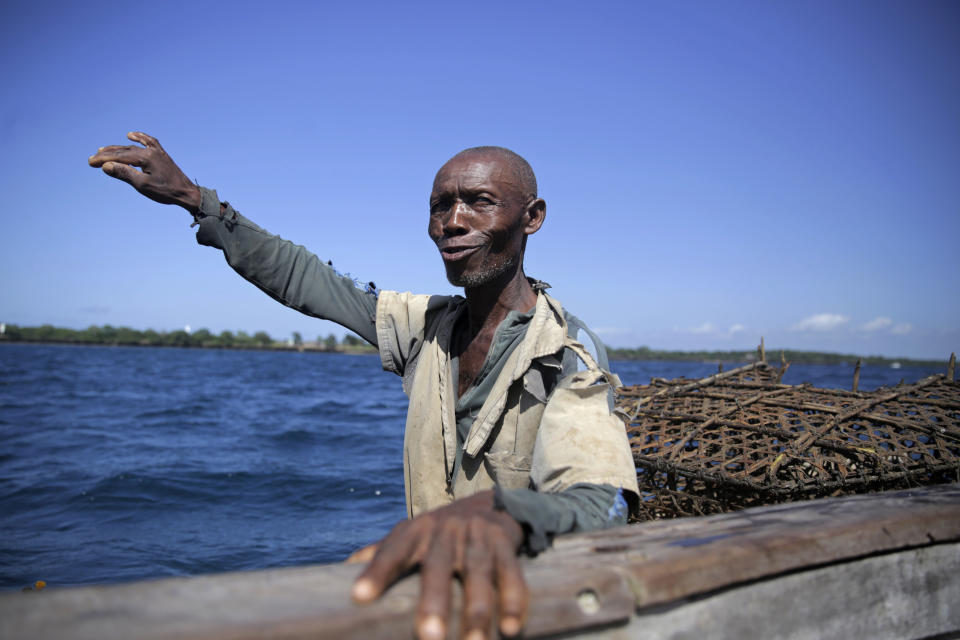 Fisherman Chapoka Miongo speaks from his traditional dugout canoe at the Shimoni channel, in Kwale county, Kenya, on Tuesday, June 14, 2022. Artisanal fisheries on Kenya's coast say climate change, overfishing by large foreign vessels and a lack of other job opportunities for coastal communities is draining the Indian Ocean of its yellowfin tuna stocks. Miongo explained that warming waters forced tuna species to alter their migration patterns, making it harder for local fishers to catch them. (AP Photo/Brian Inganga)