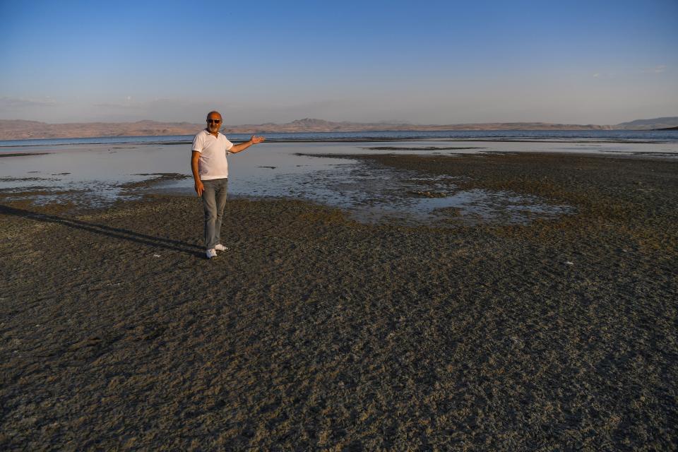 man pointing out dried up shoreline