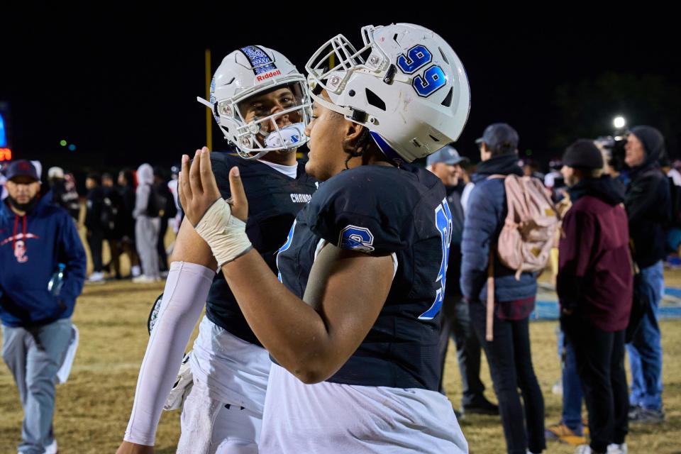 Chandler Wolves quarterback Dylan Raiola (1) and defensive tackle Alani Aonga (99) celebrate their victory over the Centennial Coyotes at Chandler High School's Austin Field on Friday, Nov. 25, 2022.