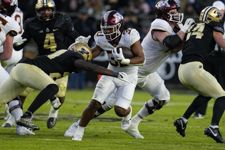 Minnesota running back Jordan Nubin (30) is tackled by Purdue defensive back Sanoussi Kane (21) during the second half of an NCAA college football game in West Lafayette, Ind., Saturday, Nov. 11, 2023. (AP Photo/Michael Conroy)