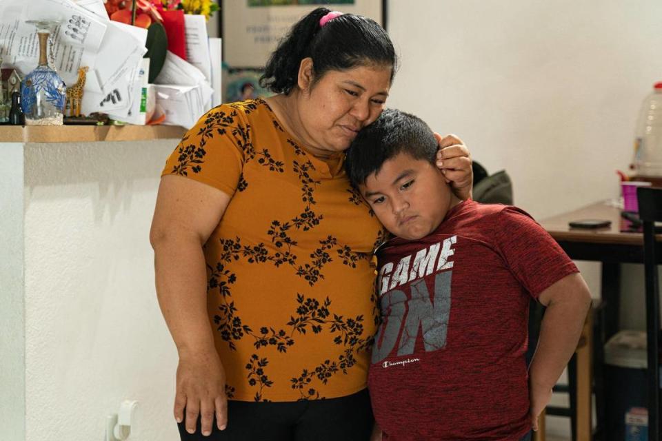 Méndez, de origen guatemalteco, cría a su familia de cinco miembros junto con su pareja en un apartamento de Homestead. En la foto, Méndez abraza a su hijo Julio en su casa, el lunes 21 de noviembre de 2022.