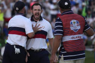 United States' Patrick Cantlay, centre celebrates with playing partner United States' Wyndham Clark, left, after winning his afternoon Fourballs match on the 18th green at the Ryder Cup golf tournament at the Marco Simone Golf Club in Guidonia Montecelio, Italy, Saturday, Sept. 30, 2023. (AP Photo/Andrew Medichini)