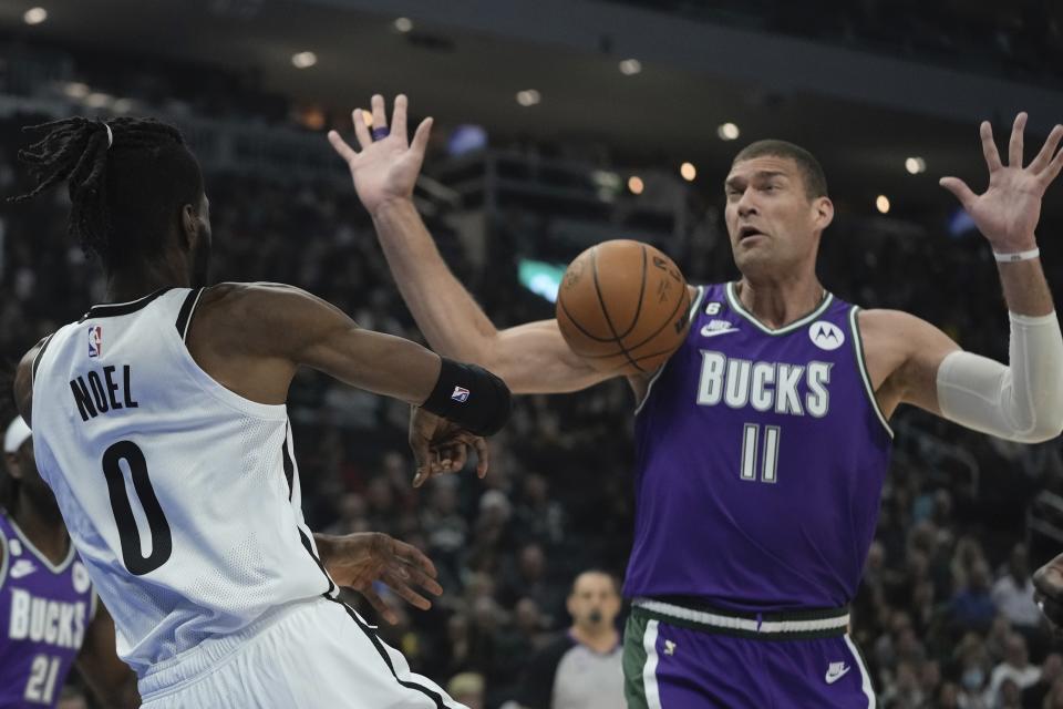 Brooklyn Nets' Royce O'Neale throws the ball off Milwaukee Bucks' Brook Lopez the first half of an NBA basketball game Thursday, March 9, 2023, in Milwaukee. (AP Photo/Morry Gash)