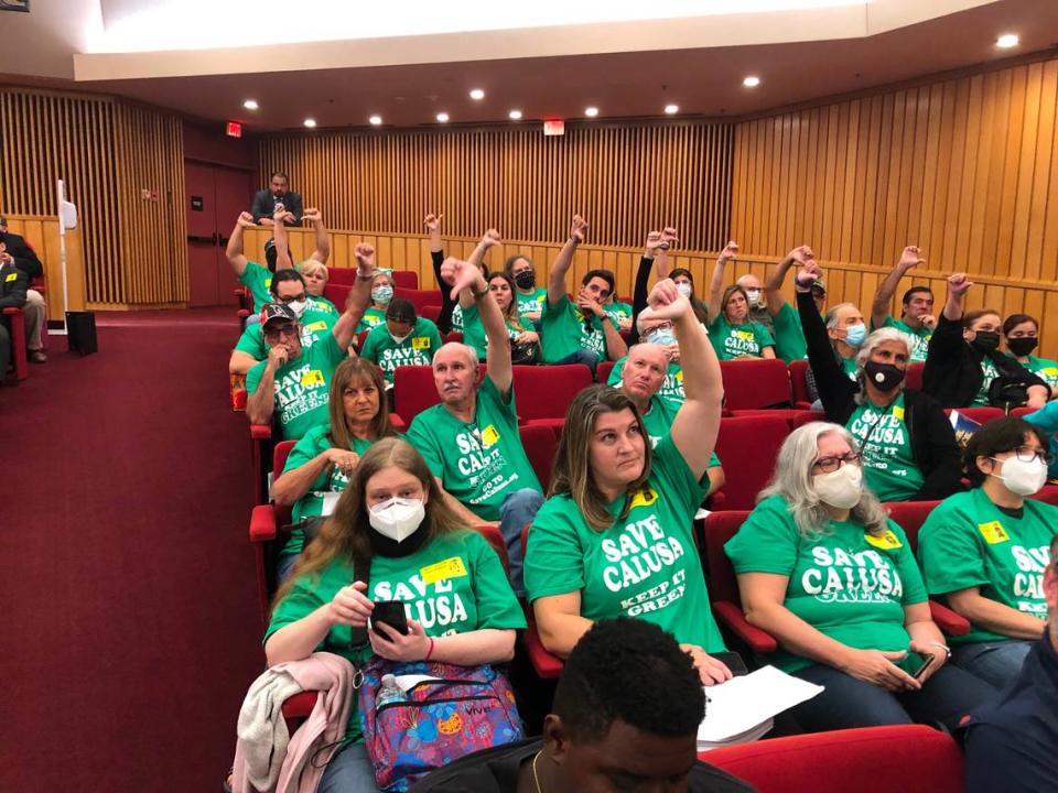 Residents opposed to a residential development on the shuttered Calusa golf course near their homes signal their disapproval during the Nov. 17, 2021 meeting of the Miami-Dade County Commission to vote on the project’s zoning approval. Save Calusa leader Amanda Prieto is in the second seat from the aisle with arm raised.