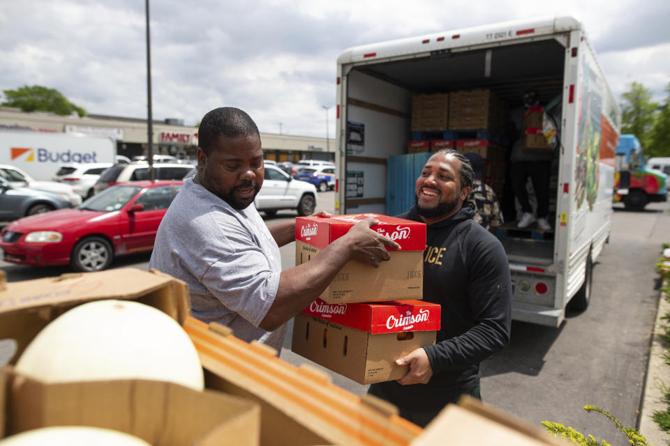 Pastor Andre Kamoche, left, and Greg Jackson, with Rehoboth House of Prayer, help unload a truck of fresh produce to be given out to people affected by the Tops Friendly Market closure, Tuesday, May 17, 2022, in Buffalo, N.Y. (AP Photo/Joshua Bessex)