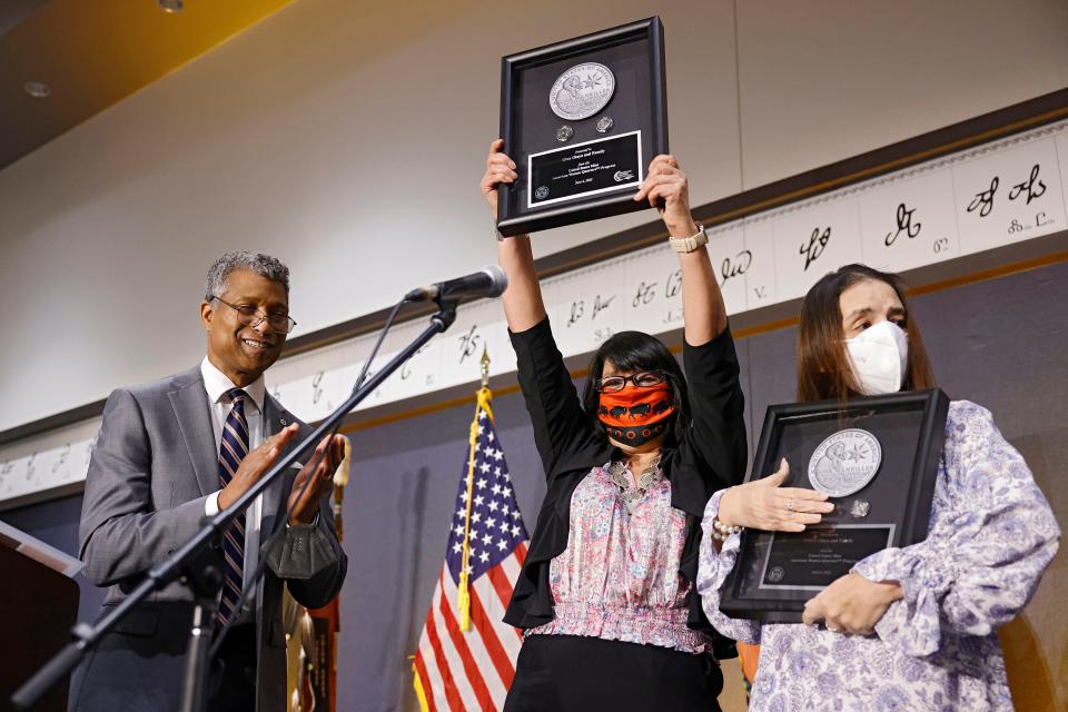 Former Cherokee Nation Principal Chief Wilma Mankiller's daughters, Felicia Olaya (center) and Gina Olaya, are presented the Wilma Mankiller quarter Monday during a ceremony celebrating the quarter's release in Tahlequah. At left is T.V. Johnson, with the United States Mint.