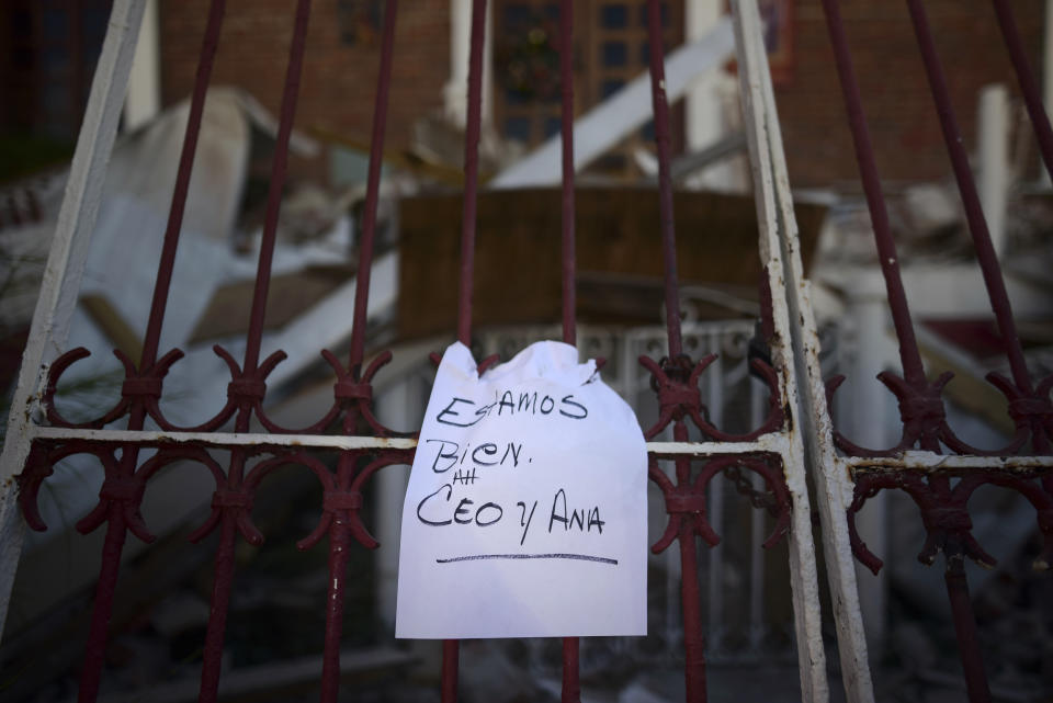 A note that reads "We're well. Ceo and Ana," hangs on a fence after an overnight earthquake in Guayanilla, Puerto Rico, Tuesday, Jan. 7, 2020. A 6.4-magnitude earthquake struck Puerto Rico before dawn on Tuesday, killing one man, injuring others and collapsing buildings in the southern part of the island. (AP Photo/Carlos Giusti)