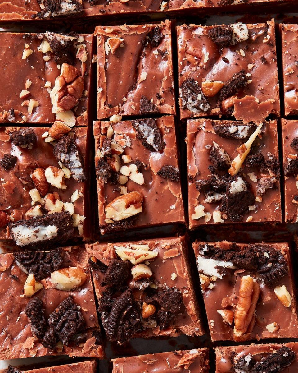 closeup of pieces of fantasy fudge topped with pecans and crushed oreos