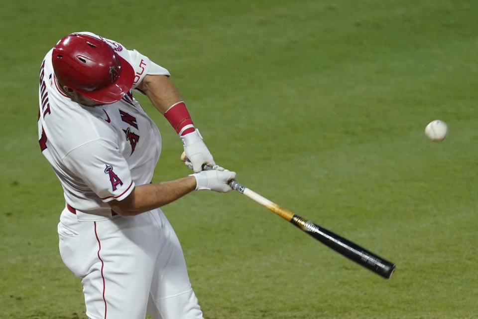 Los Angeles Angels' Mike Trout hits a foul ball which was caught by Texas Rangers right fielder Joey Gallo during the third inning of a baseball game Friday, Sept. 18, 2020, in Anaheim, Calif. (AP Photo/Ashley Landis)