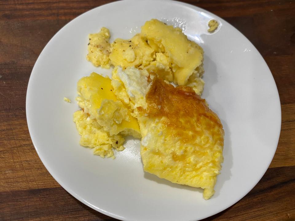 Chunks of scrambled eggs, some areas browned, on a white plate